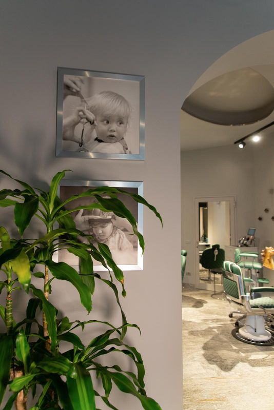 L'ingresso: una pianta, due fotografie in bianco e nero e l'arco che porta alla sala